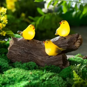 yellow finches on a log solar garden sculpture
